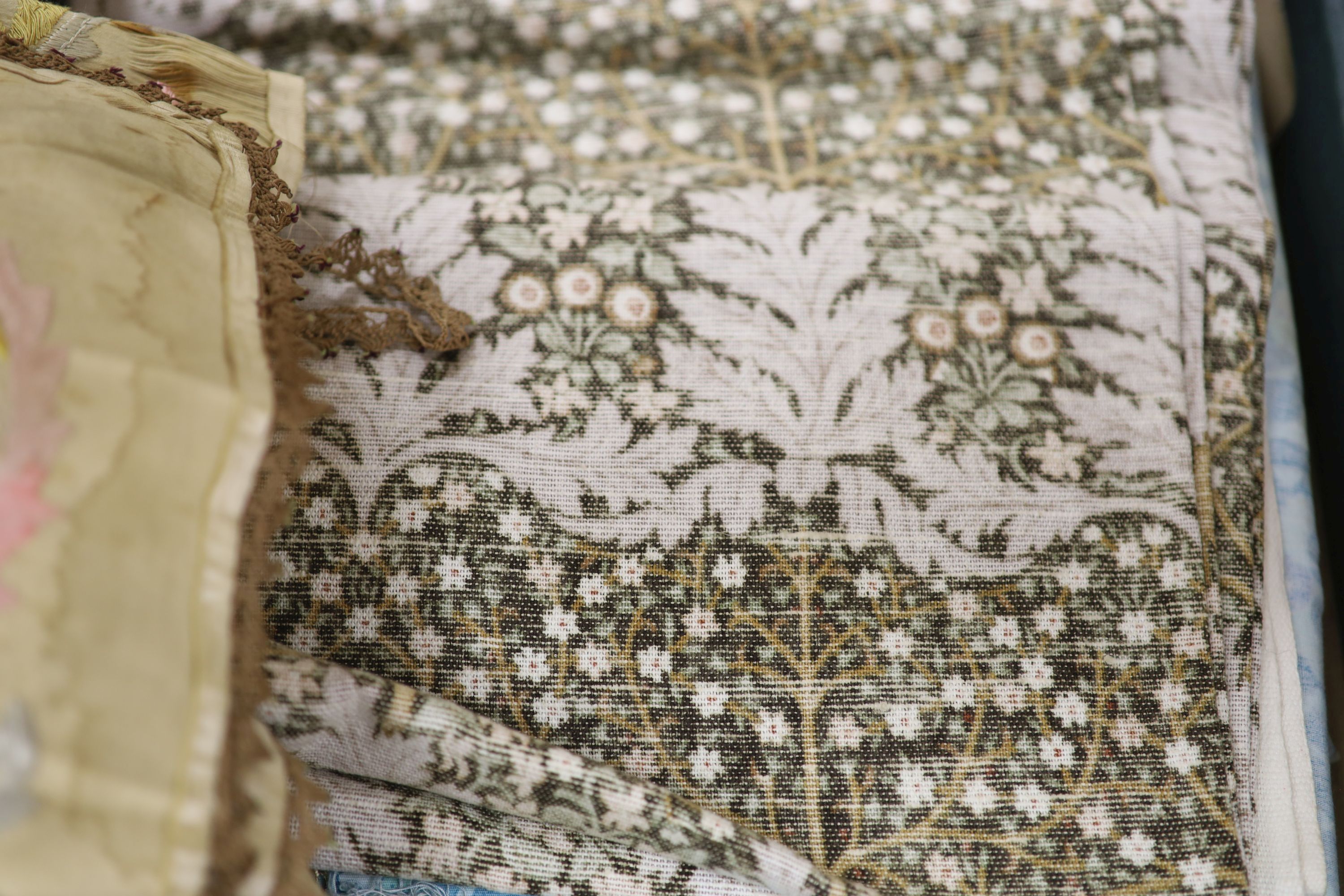 A red brocade dressing gown, embroidered silk runner, Indian panel, Liberty Morris style fabric etc